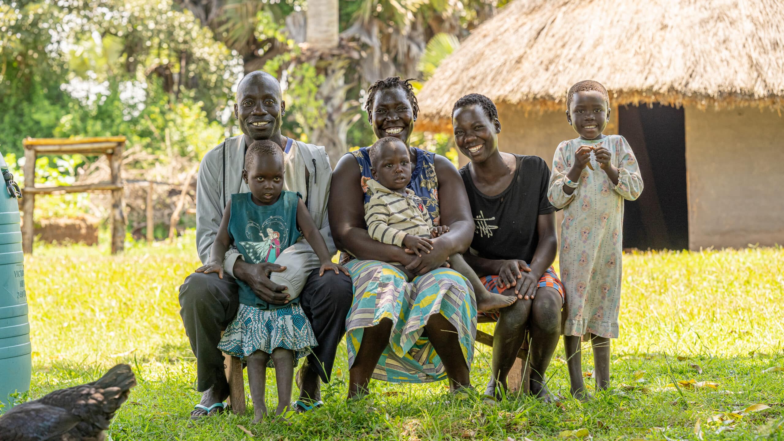 Sharon with her family outside their home in Amuru.