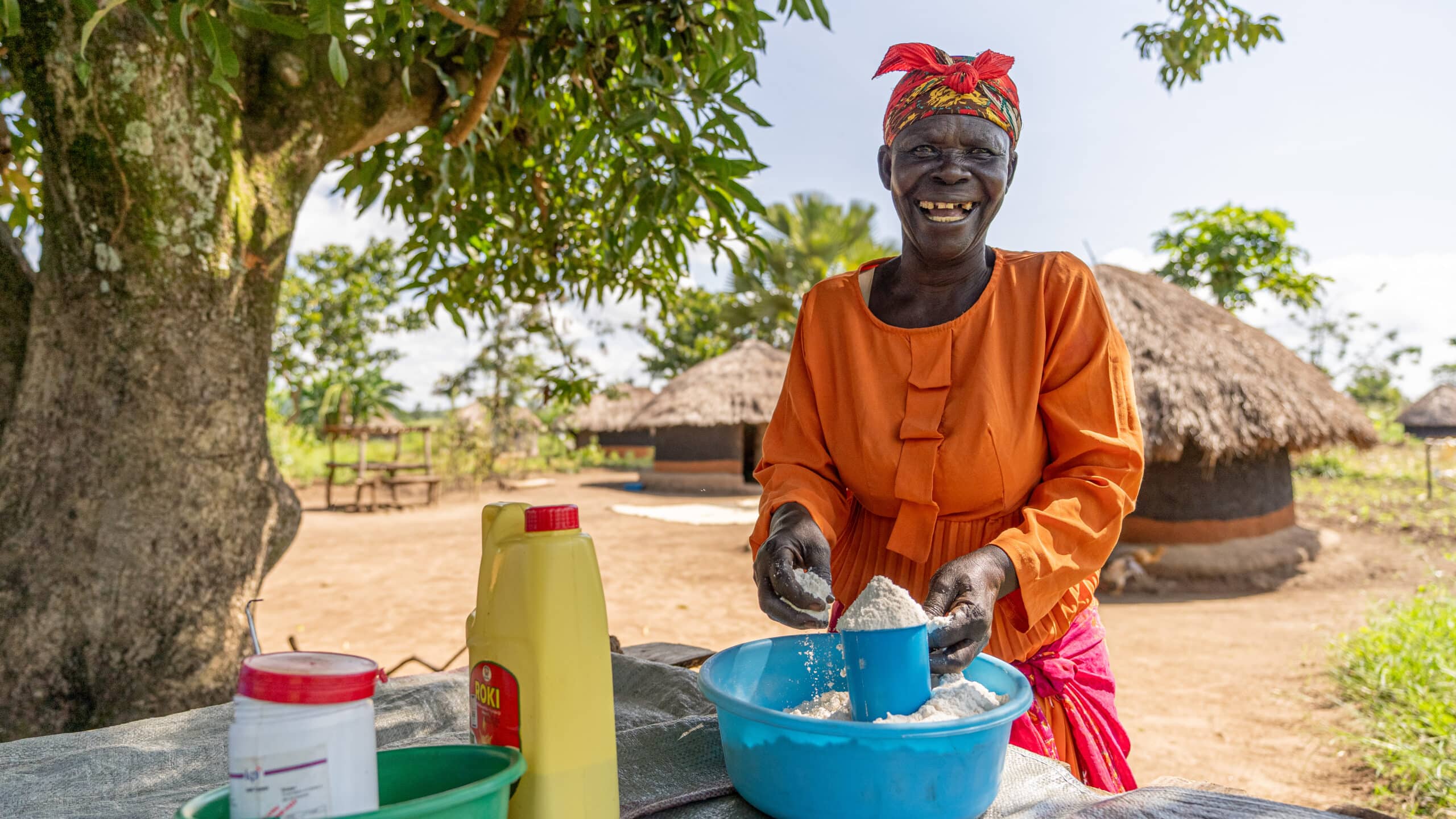 Oryema selling maize flour and produce at her stall