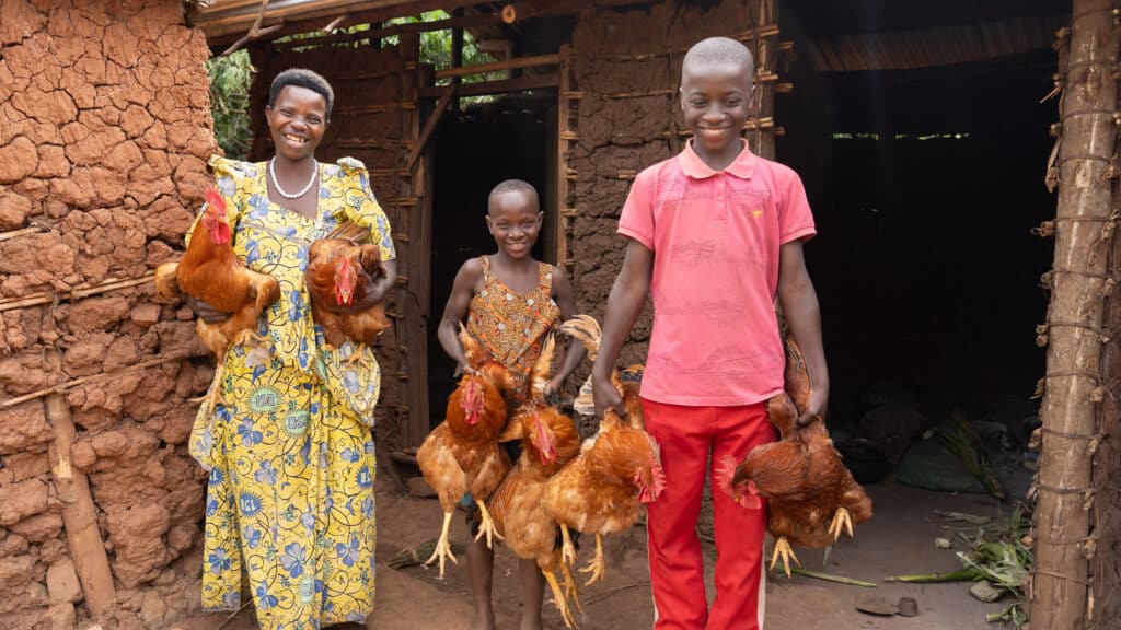 Grace and her children with chickens from their poultry farm